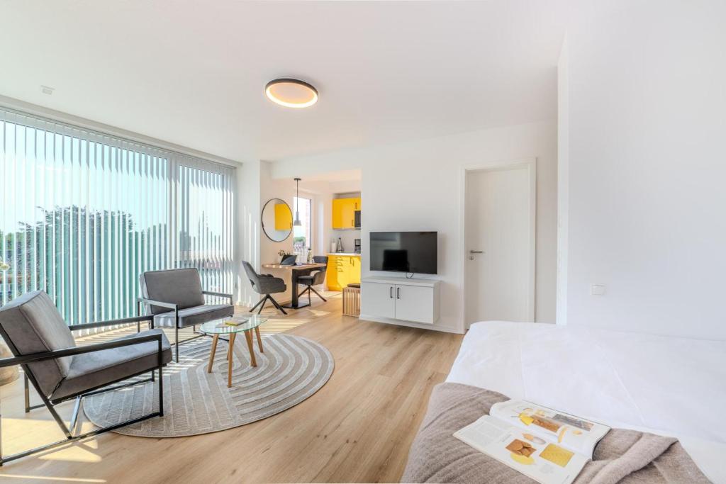 a bedroom with a bed and a living room at Stadtloft Penthouse "Eversten" Neubau Business Apartments für Projekt- und Firmenaufenthalte in Oldenburg