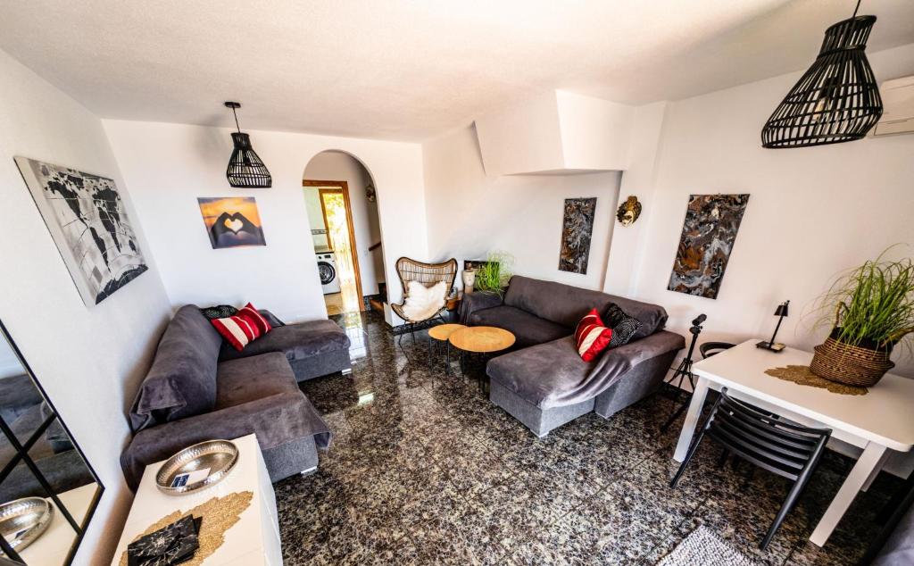 un salon avec des canapés et une table dans l'établissement SunRise Den, a pie de playa, vista al mar y piscina, à El Alamillo