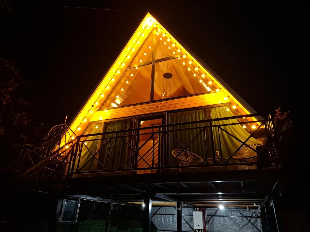 a pyramid shaped house with lights on it at night at your dream cottage in Ts'ikhisdziri