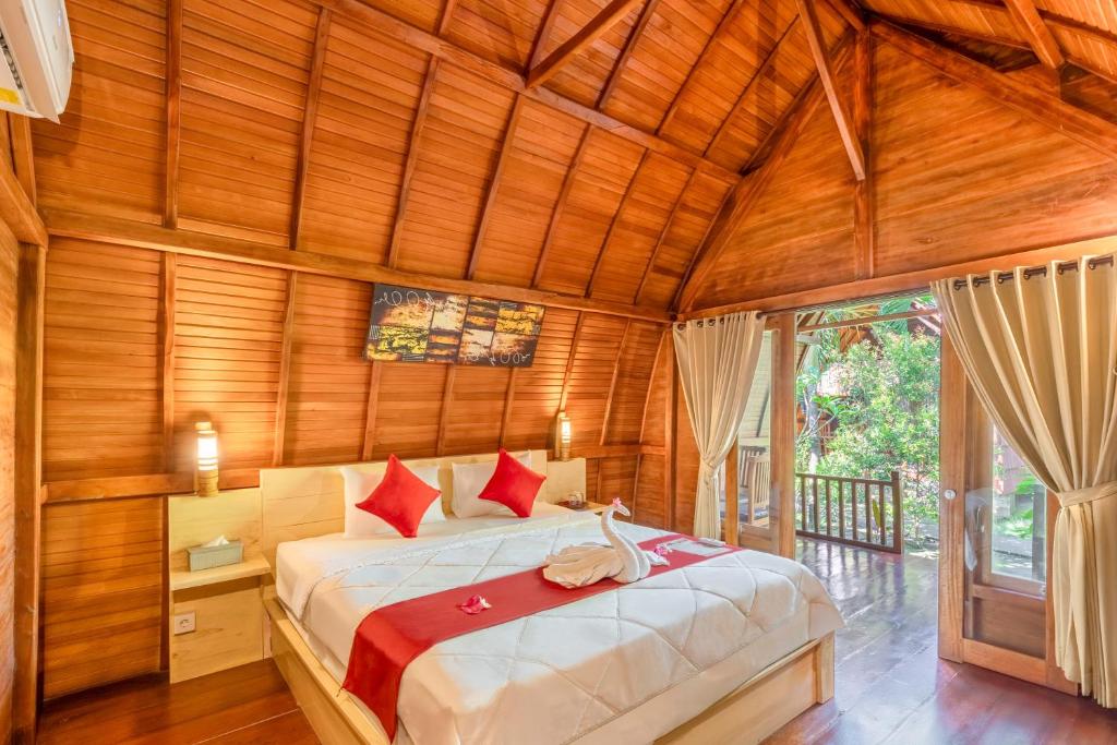 Un dormitorio con una cama en una habitación con paredes de madera. en Maha Nusa Menjangan, en Banyuwedang
