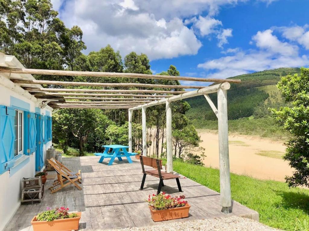 a patio of a house with a table and benches at Esteiro Surf Lodge in Santa Marta de Ortigueira