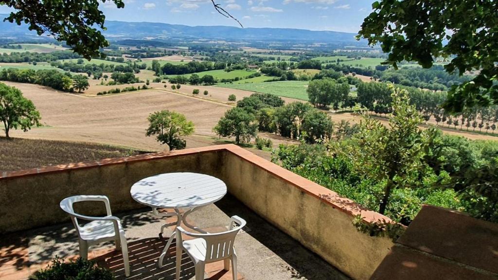 stół i 2 krzesła na balkonie z widokiem w obiekcie Le Refuge du Tarn - Grand Jardin w mieście Puylaurens