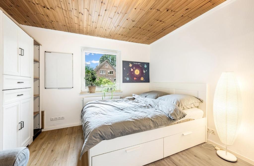ein Schlafzimmer mit einem Bett mit Holzdecke in der Unterkunft Gemütliches kleines Haus mit 3-4 Schlafplätzen in Ritterhude