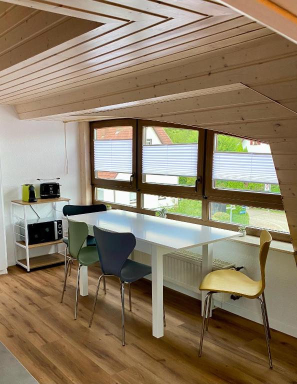 a dining room with a white table and chairs at Moderne Monteur- und Ferienwohnung am Plettenberg in Dotternhausen