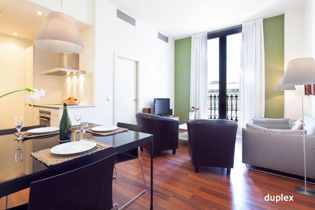 een woonkamer met een tafel, stoelen en een bank bij Inside Barcelona Apartments Mercat in Barcelona