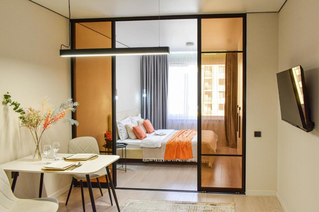 a room with a bed and a dining room with a table at Auezov Apart in Almaty