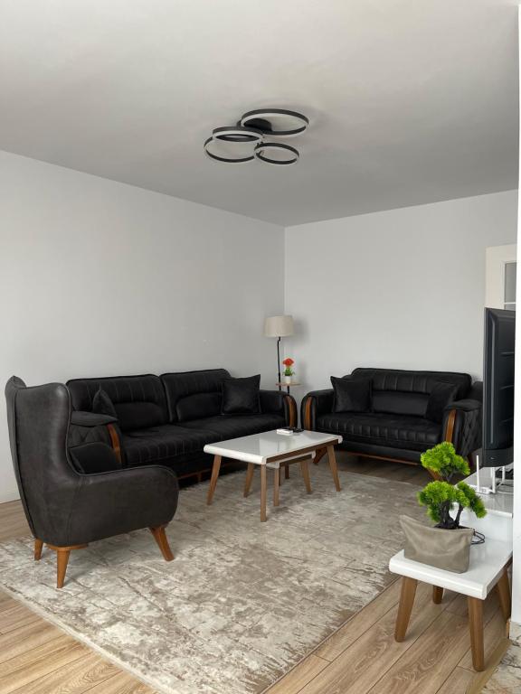 a living room with two black couches and a table at City View Prishtina in Pristina