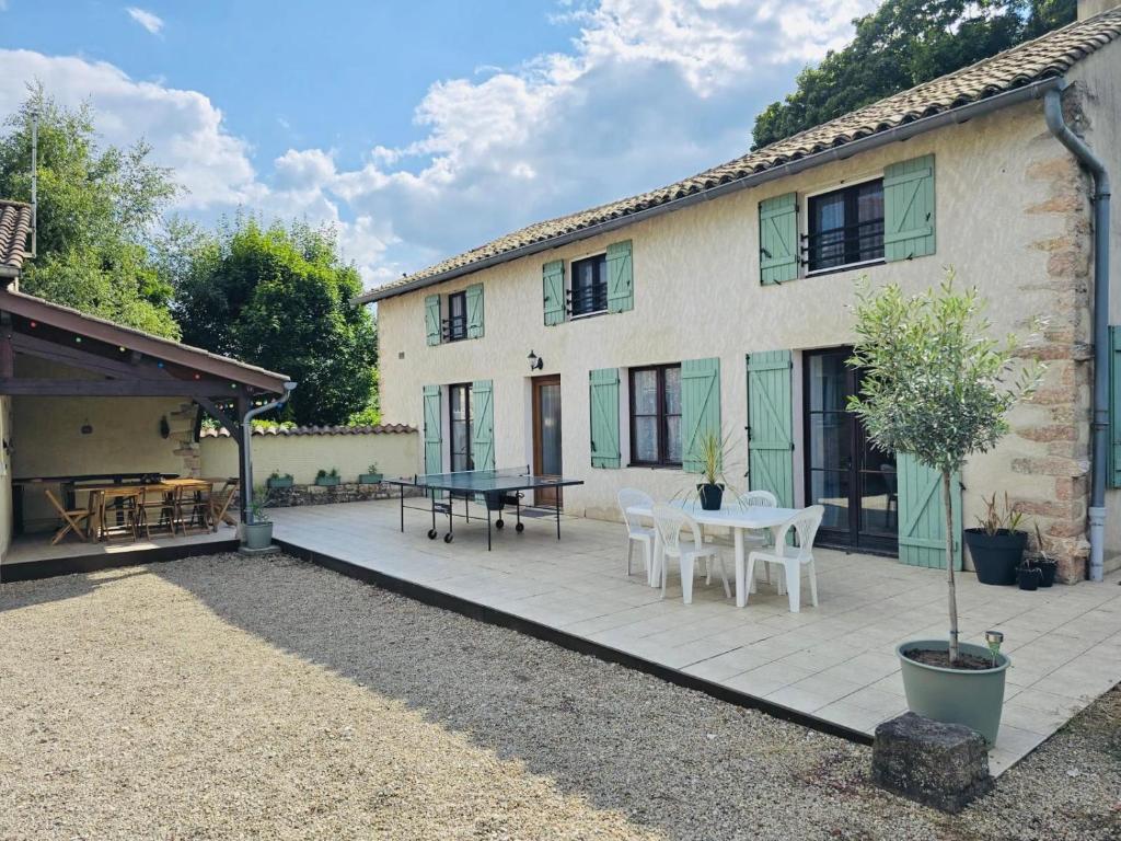 a house with a patio with a table and chairs at Family House With Garden For 8 At Prety in Préty