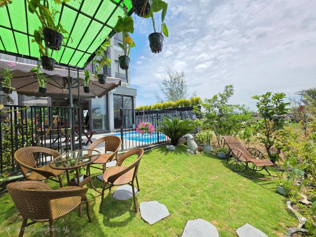 un patio avec une table et des chaises et une piscine dans l'établissement Ngọc Quyên Villa, à Hiếu Nhơn