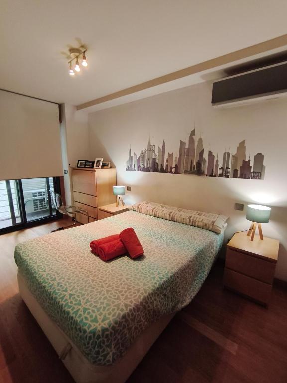 a bedroom with a bed with a red pillow on it at Pleno centro, 5 minutos Casco Vello, 400 metros estación AVE in Vigo