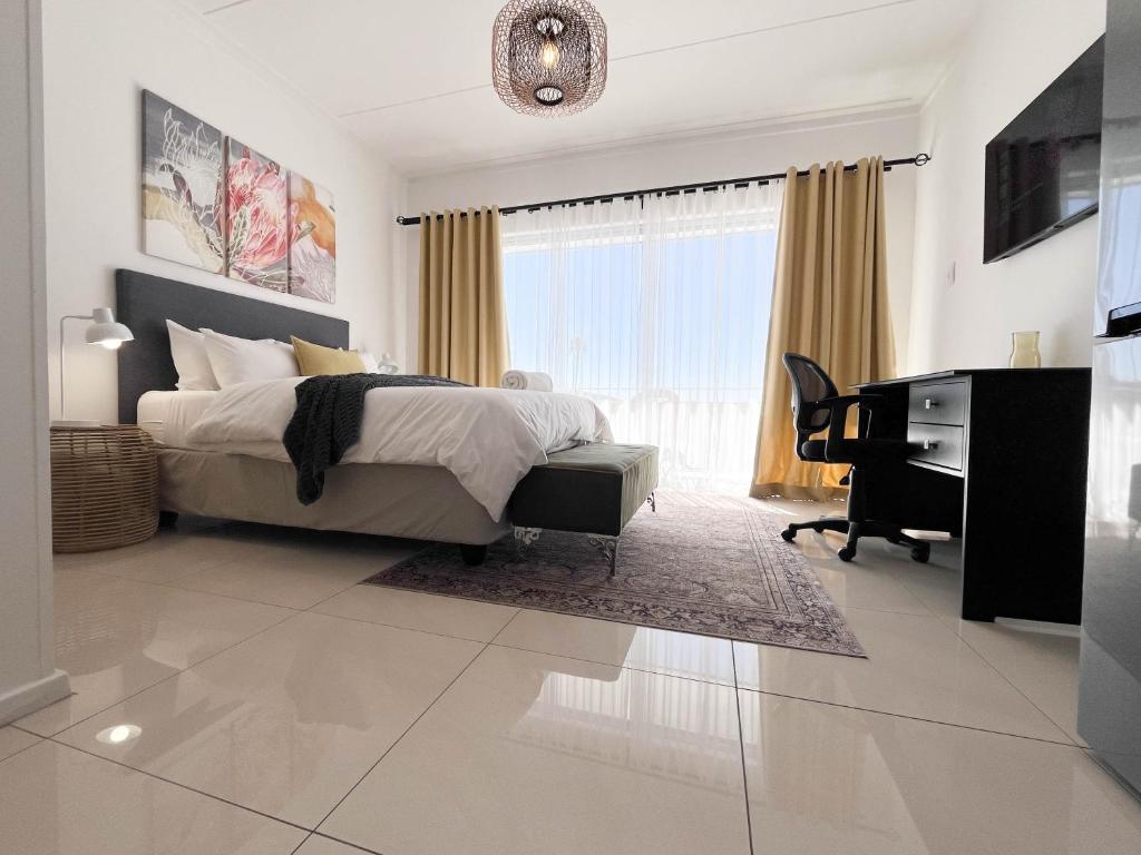 a bedroom with a bed and a desk and a computer at Comfort Zone Suites - Hidas 2 in Windhoek