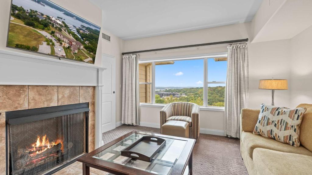 a living room with a fireplace and a tv at Avila Serenity Suites - For 6 in Lake Ozark