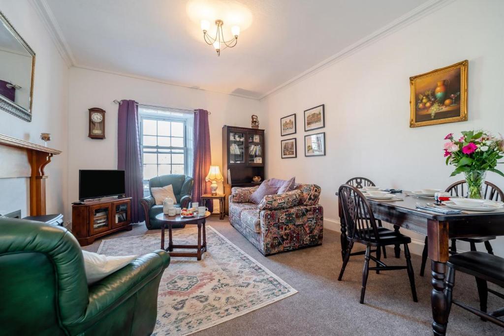 sala de estar con muebles y mesa. en Annandale House, en Moffat