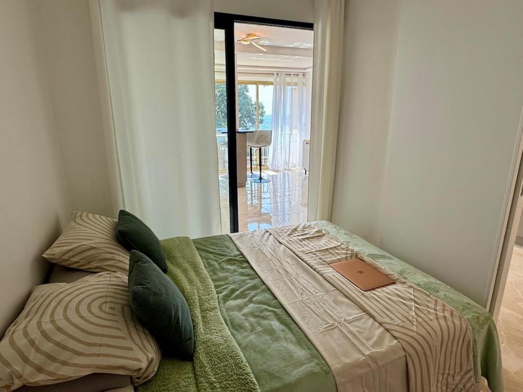a bedroom with a bed with a book on it at Luxury Apartment with Sea View and Private Beach Access in Cannes