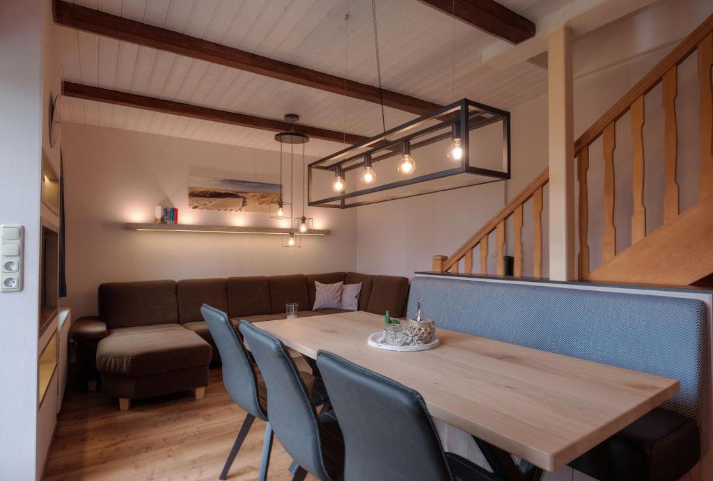 a dining room with a wooden table and chairs at Deichgraf in Stinteck