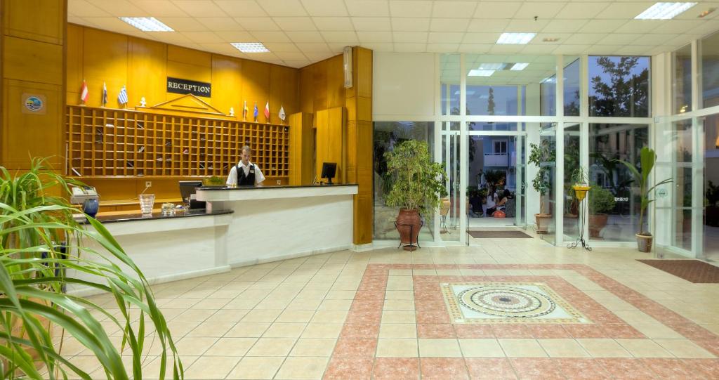 a lobby with a counter in a building at Corali Hotel in Tigaki