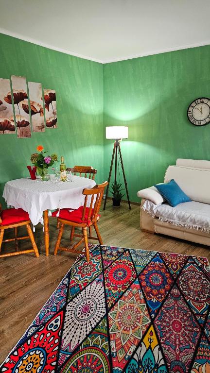 a living room with a table and a green wall at Apartment Dukat Vršac in Vršac