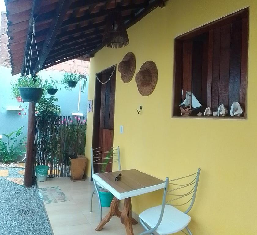 Flores do Riacho- Chalés في ساو ميغيل دوس ميلاجريس: طاولة وكراسي أمام منزل
