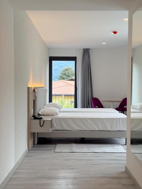 a bedroom with a large bed and a window at Lake & More Suite Hotel in Paratico