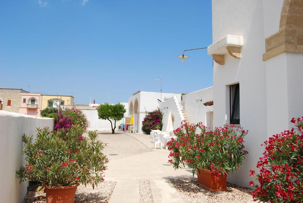 a street with white buildings and flowers in pots at Terra di Leuca in Salve