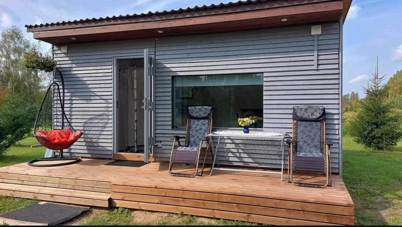 una casa con 2 sillas y una mesa en una terraza en Välja Puhkemaja, en Üksnurme