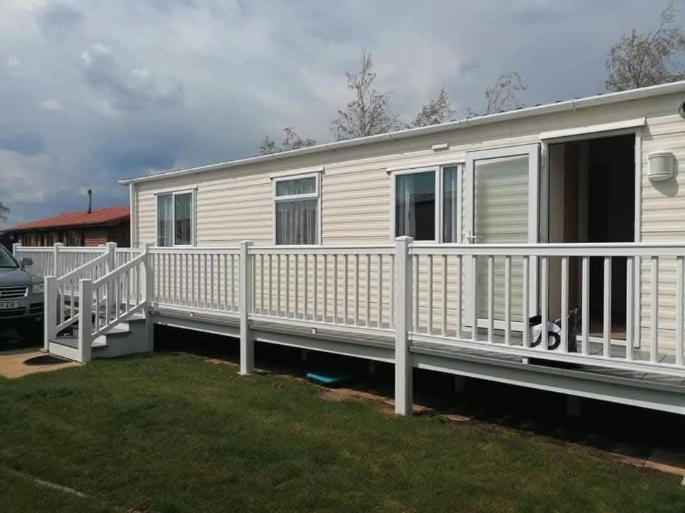 una casa móvil con una cerca de riel blanca en Misty bay, en Tattershall