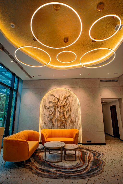 a lobby with an orange couch and a table at Welina Hotel in Bhubaneshwar