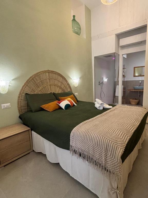 a bedroom with a large bed with green sheets and orange pillows at Panta Rei 97 in Barletta