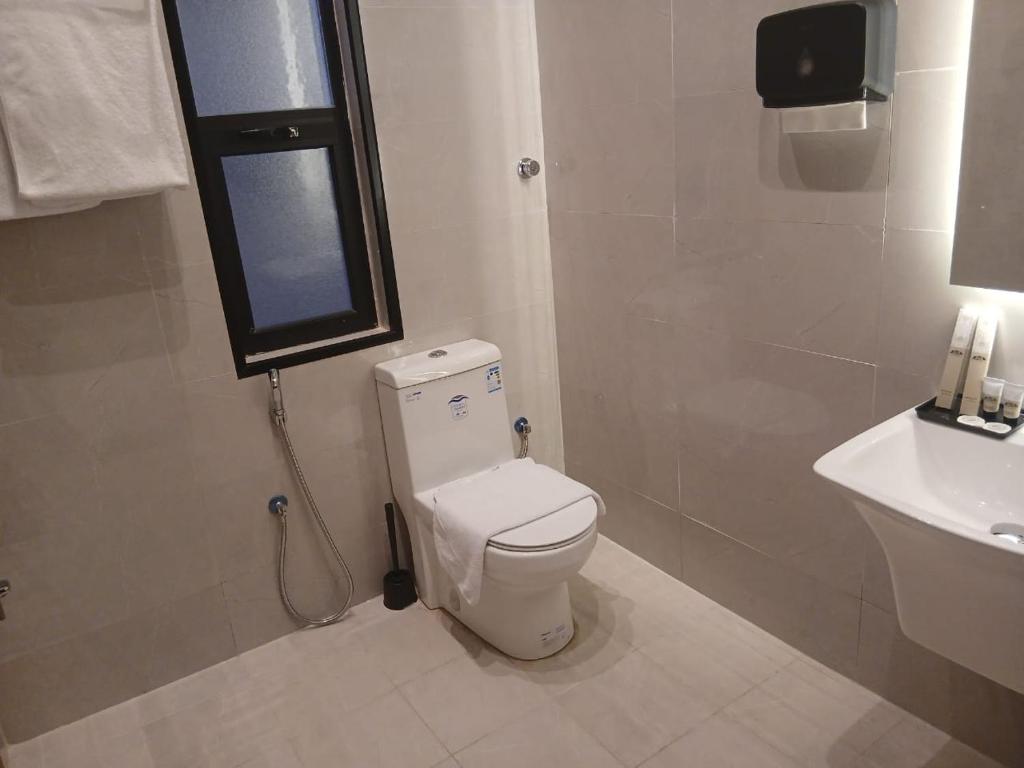 un baño con inodoro y lavabo en W Hotel Apartment, en Taif