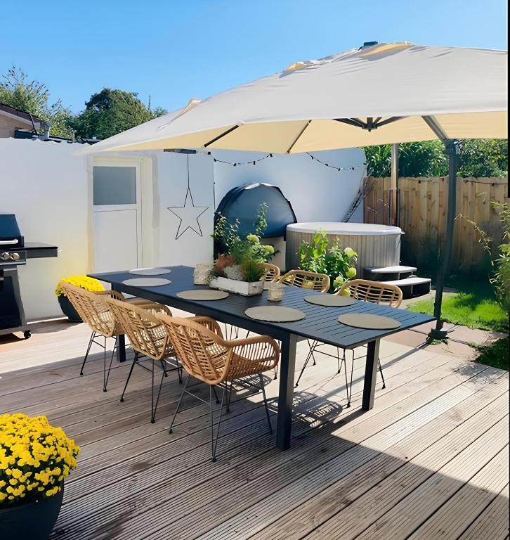 a patio with a table and chairs under an umbrella at Ferienhaus Visselheide in Visselhövede
