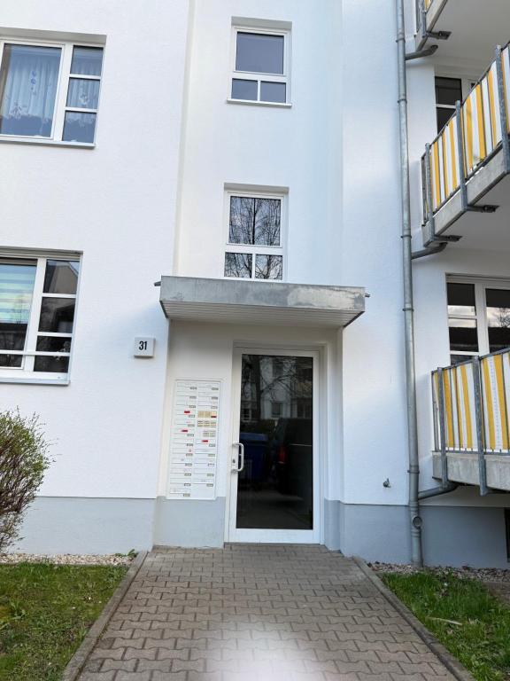 a white building with a door and a balcony at Carrée 31 Balkon, Privatparkplatz, Aufzug, Kaffee in Chemnitz