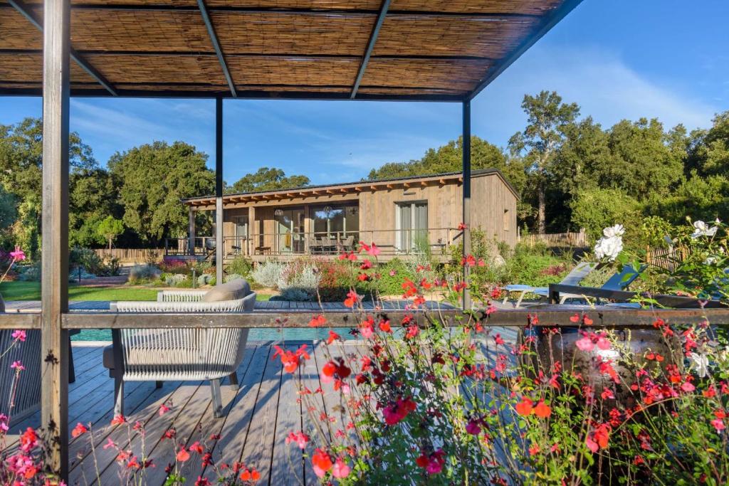 a patio with flowers and a house at Lodge Les Oliviers Di Lecci in Lecci