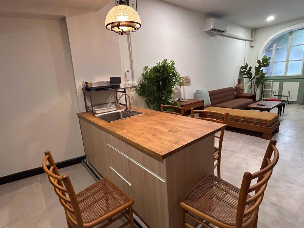 a kitchen and living room with a counter and chairs at Ni Haus, cozy place for 4 people in Bangkok