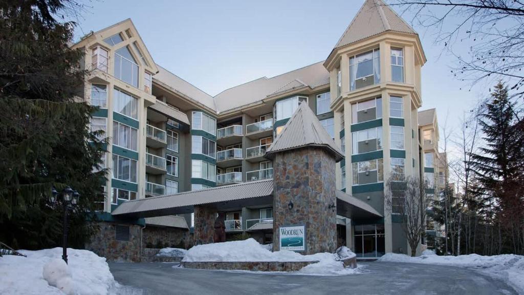 a large apartment building with snow in front of it at Woodrun Lodge 414 | Cozy Ski-In Ski-Out Condo w/ Shared Hot Tub, Pool, Fireplace, & Parking in Whistler
