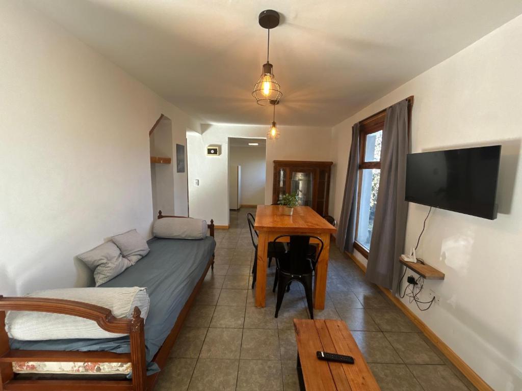 a bedroom with a bed and a table and a television at Sombra Verde - Alojamiento Turistico in Villa La Angostura