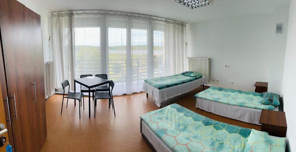 a room with two beds and a table and chairs at Twój Hostel Bytom in Bytom