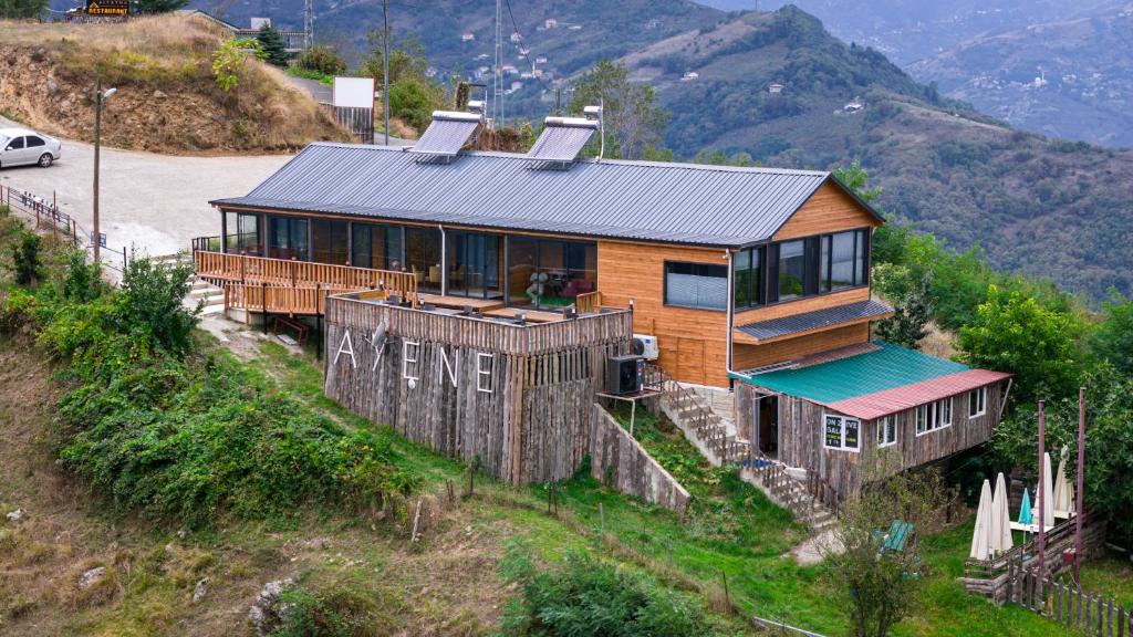 una casa en la ladera de una colina con montañas en Trabzon Bungalov, en Akcaabat