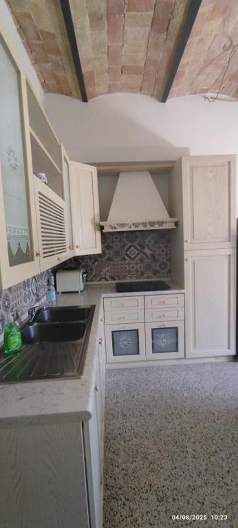 a small kitchen with white cabinets and a sink at Civico 95 Alloggio Turistico in Marta