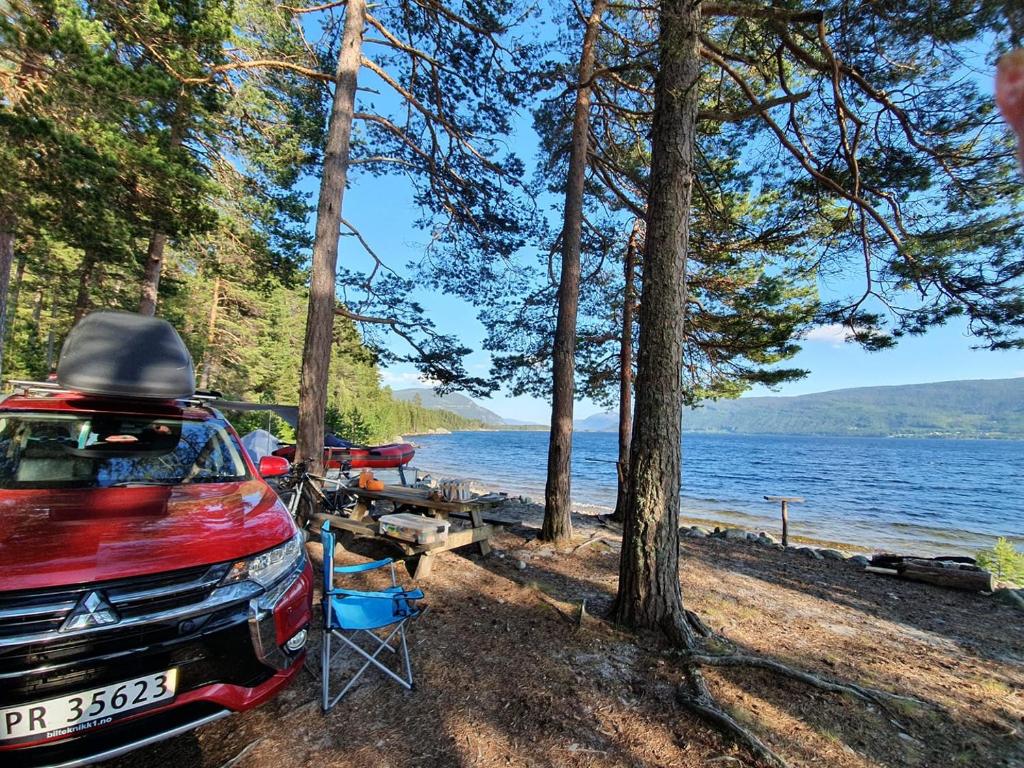 un'auto parcheggiata accanto a un lago con un tavolo da picnic di Mitsubishi med telt og camping utstyr a Sandnes