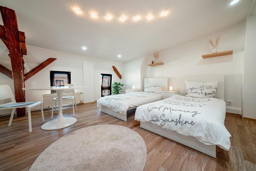 a bedroom with two beds and a table and a rug at Charming old building for 2 in Magdeburg