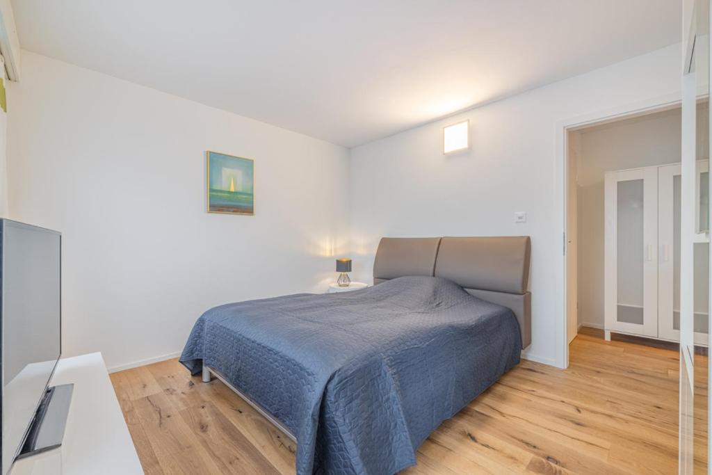 une chambre avec un lit dans une pièce blanche dans l'établissement Aparthotel Seiler Mama Home, à Arbon