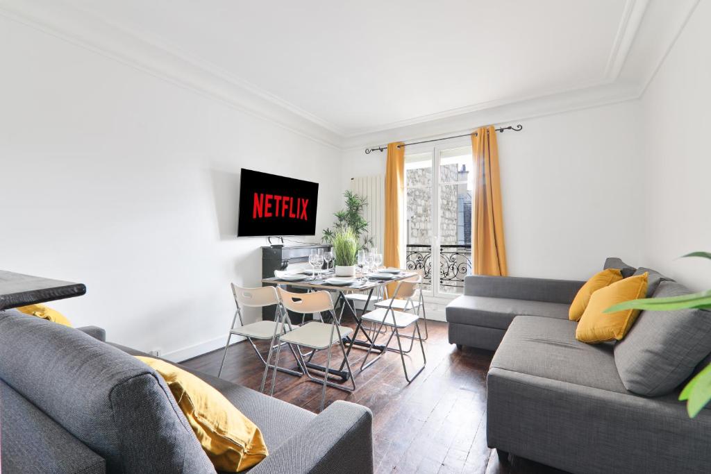 a living room with a couch and a table with a tv at Heart of Paris-1BR-2P-Montparnasse -Free Netflix in Paris