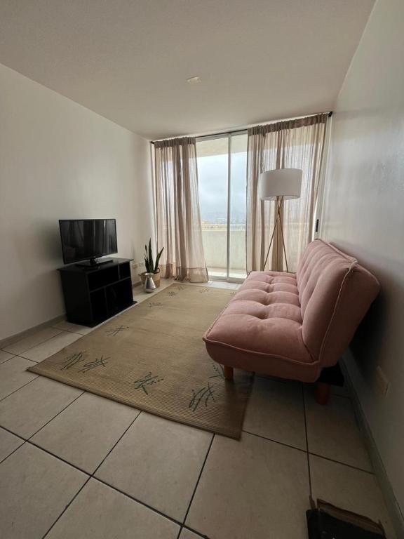 a living room with a couch and a television at La Serena, Vista al mar y piscina in Coquimbo