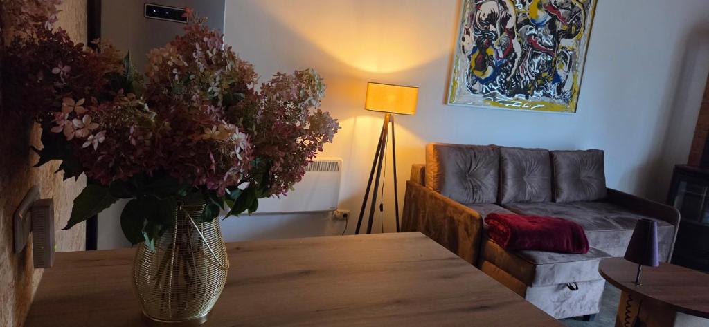 a living room with a table and a vase of flowers at Ferienhaus LODA - Garten, Netflix & Spreewald Flair in Heinersbrück