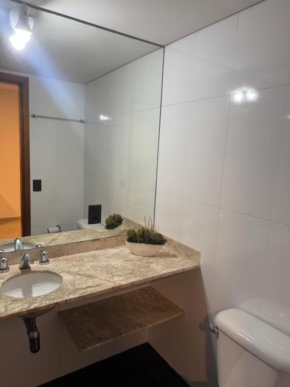 un baño con lavabo y espejo en Flat Congonhas sp, en São Paulo