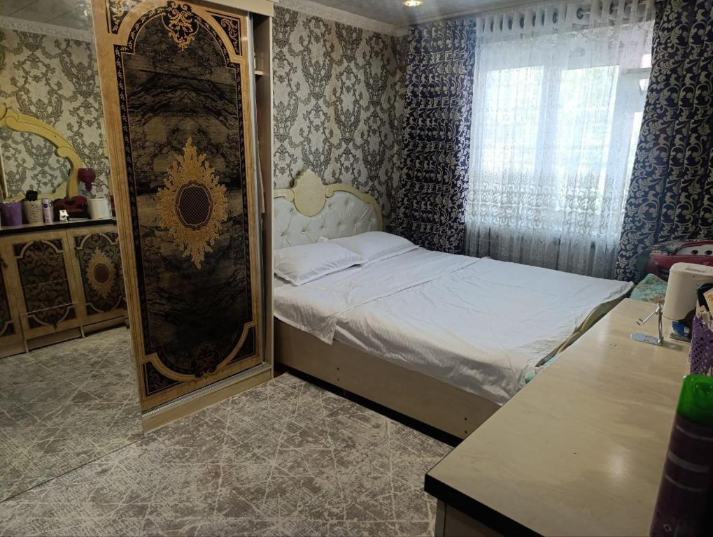 サマルカンドにあるYasmin Apartmentのベッドと鏡のある小さな寝室
