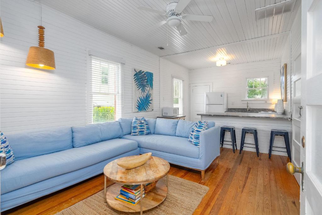 a living room with a blue couch and a table at Shirley Road Cottage by Tybee Cottages in Tybee Island