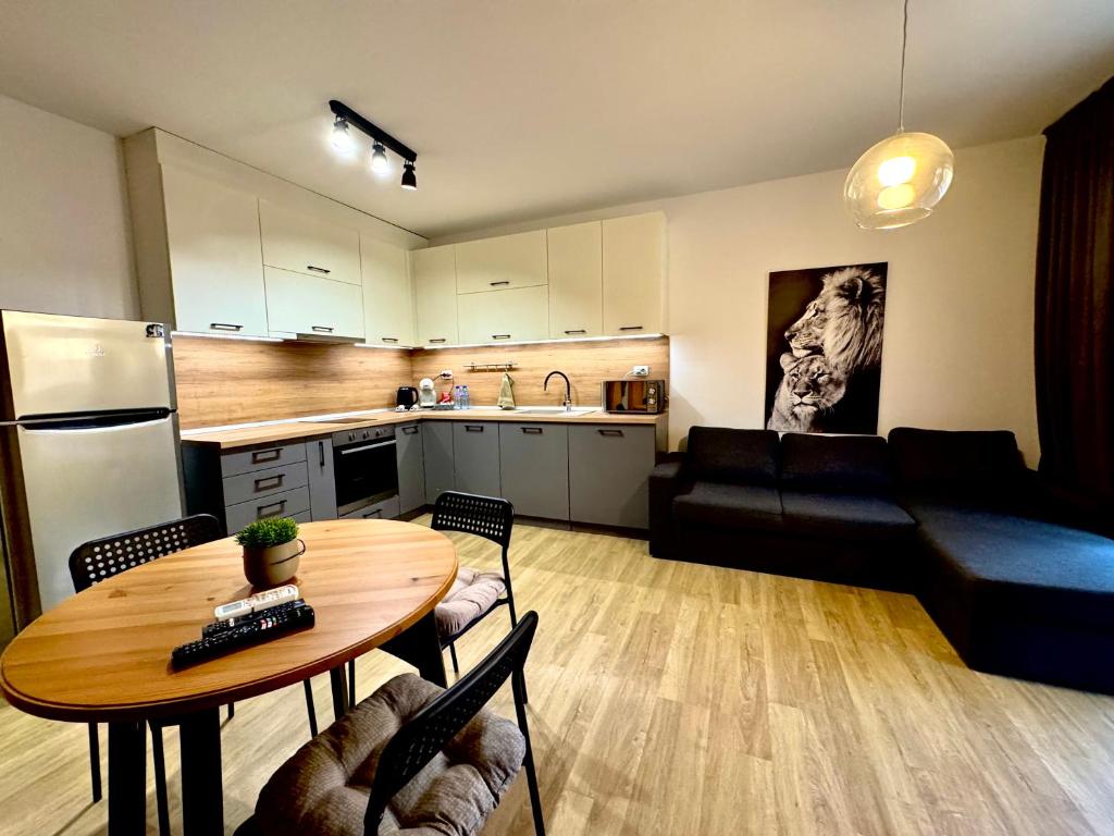 Una cocina y una sala de estar con una mesa y un sofá. en Studio Sredec 77, en Plovdiv