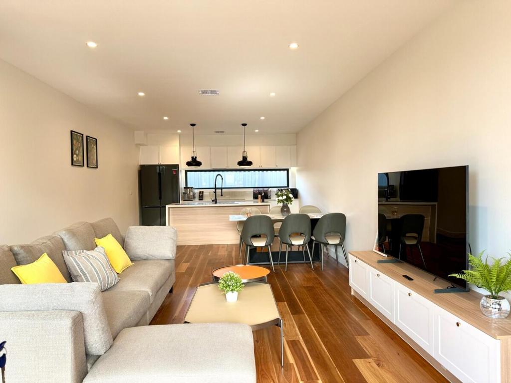 a living room with a couch and a kitchen at Williamstown Village in Williamstown