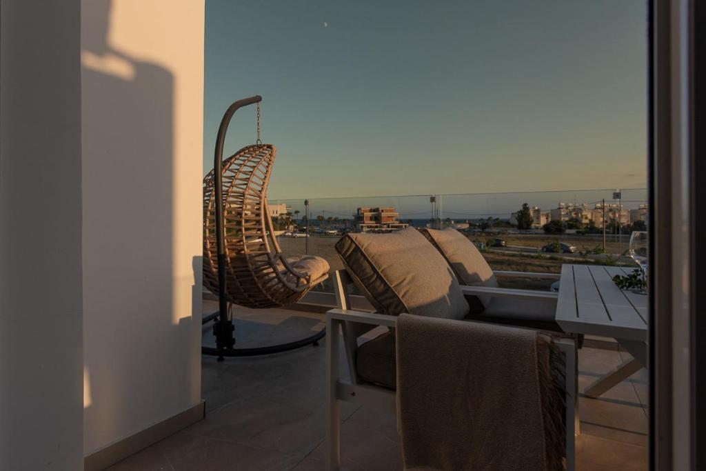 un balcon avec deux chaises et une table avec vue dans l'établissement TelMar SeaView, à Oroklini